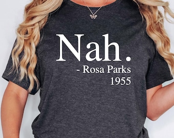 May include: A dark gray heather t-shirt with the text "Nah." and "Rosa Parks 1955" printed in white.
