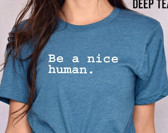 May include: A teal blue t-shirt with the text "Be a nice human." printed in white.