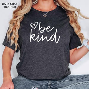 May include: A dark gray heather t-shirt with a white graphic that says "be kind" with a heart symbol.