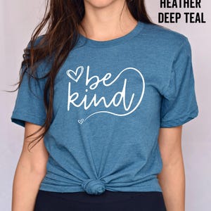 May include: A teal blue t-shirt with the text "be kind" in white lettering with a heart design.