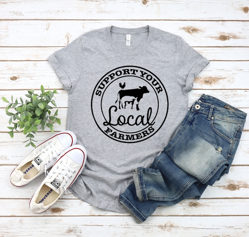 May include: A gray t-shirt with a black circle graphic that says "Support Your Local Farmers" with a cow, chicken, and pig inside the circle.
