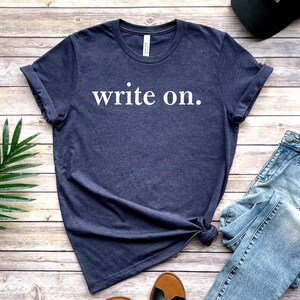 May include: A dark blue t-shirt with the text "write on." printed in white.