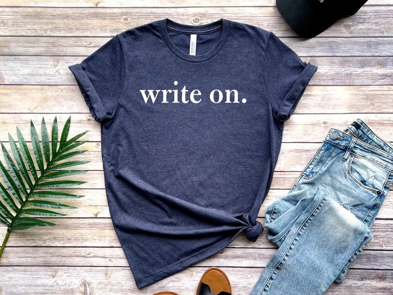 May include: A dark blue t-shirt with the text "write on." printed in white.