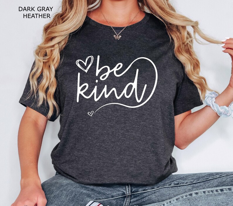 May include: A dark gray heather t-shirt with the text "be kind" in white cursive lettering and a heart design.