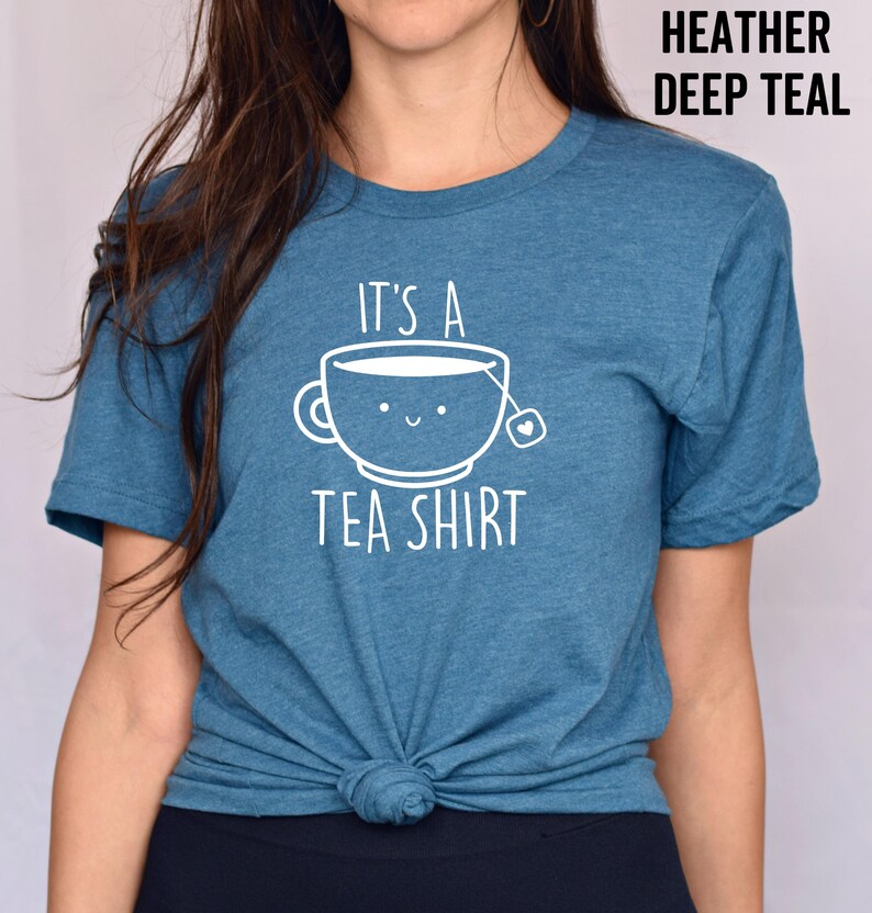 May include: A teal blue t-shirt with the text "It's a Tea Shirt" and a cartoon teacup with a smiling face.