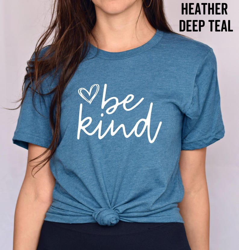 May include: A teal blue t-shirt with a white heart and the text "be kind" printed on the front.