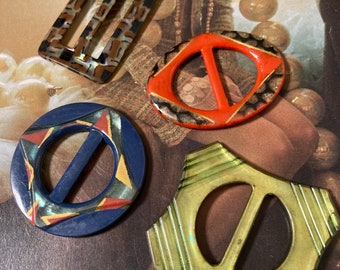 4 buckles with a thin sheet of celluloid securing the metal back