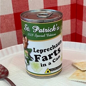 May include: A green and white can with a leprechaun illustration and the text "St. Patrick's 2025 Special Edition Leprechaun Farts in a Can". The can has a warning label that reads "CAUTION explosive contents under pressure".