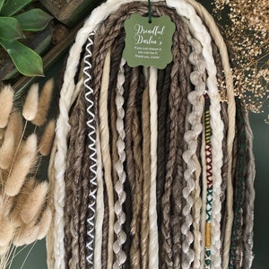 May include: A set of brown, beige and white synthetic dreadlocks with beads and a tag that reads "Dreadful Darlin's If you can dream it, you can be it. Thank you, Darlin'"