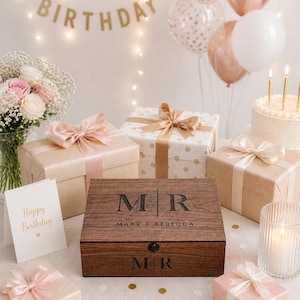 May include: A festive birthday scene with gifts, balloons, and a cake. A wooden box with "MR MARK & REBECCA" is the centerpiece, surrounded by wrapped presents with ribbons. A "Happy Birthday" banner and card add to the celebratory atmosphere.