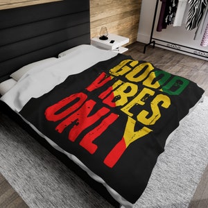 May include: Black bedspread with the words "Good Vibes Only" in yellow, red, and green lettering. The lettering is stylized and has a distressed look.