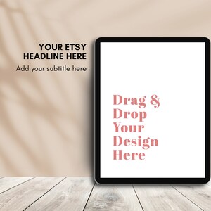 May include: A black tablet with a white screen displaying the text "Drag & Drop Your Design Here" in pink. The background features the text "YOUR ETSY HEADLINE HERE" and "Add your subtitle here". The tablet rests on a light wood surface.
