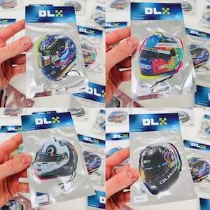 Puede incluir: Cuatro ambientadores de coche diferentes en un embalaje de pl&aacute;stico transparente. Cada ambientador presenta un dise&ntilde;o de casco de carreras diferente. Los cascos est&aacute;n impresos con varios patrocinadores y logotipos. Los ambientadores est&aacute;n etiquetados con los aromas "Cereza", "Hielo negro", "Lavanda" y "Eucalipto".