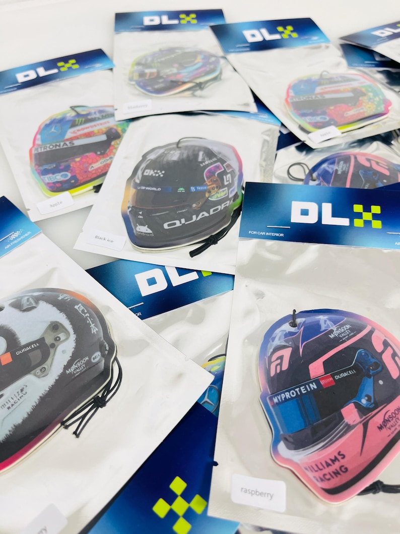 Puede incluir: Surtido de ambientadores para coche con diversos cascos de pilotos de F&oacute;rmula 1. Los ambientadores est&aacute;n envasados en bolsas de pl&aacute;stico transparentes con un logotipo DLX negro y amarillo. Los cascos est&aacute;n impresos con varios patrocinadores y logotipos, incluidos Williams Racing, Myprotein y Duracell.