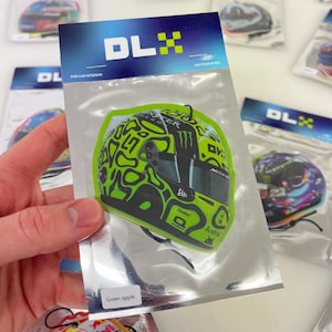 Puede incluir: Ambientador de coche con aroma a manzana verde que presenta un casco de carreras negro y verde con un logotipo de Monster Energy y el texto "USHART" y "Android".