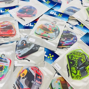May include: A variety of colorful car air fresheners featuring different race car helmets and logos. The air fresheners are packaged in clear plastic bags with a blue and white DLX logo.