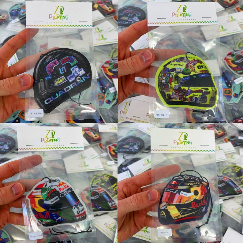 以下が含まれることがあります： プラスチック製の袋に入った、異なる4種類の車の芳香剤。各芳香剤は、レーシングカーのヘルメットの印刷画像です。香りは、ブラックアイス、パイナップル、フォレストフレッシュ、チェリーです。