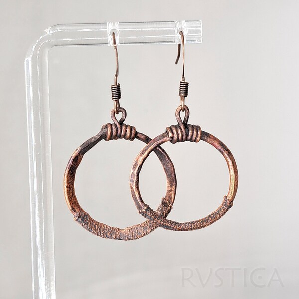 Textured copper hammered earrings boast a handmade charm, with a rough-hewn surface evoking a rustic allure.