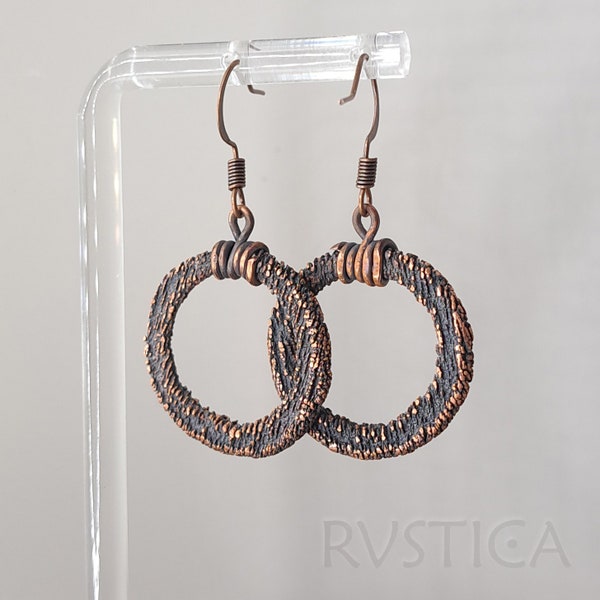 Circular copper earrings with coarse, grainy texture exude rustic charm, adding a bold, rugged edge to your ensemble.