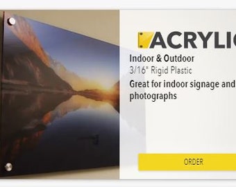 Op de afbeelding: Acryldruk van een landschap met een bergketen die weerspiegeld wordt in een meer bij zonsondergang. De print is gemonteerd met zilverkleurige hardware. De tekst luidt "Acrylic" en "Indoor & Outdoor 0,48 cm Rigid Plastic".