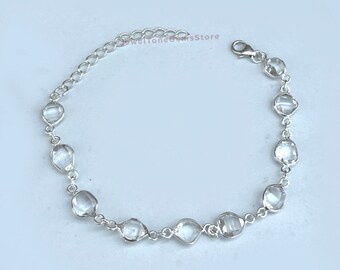 May include: A silver bracelet with a chain and clear faceted stones.