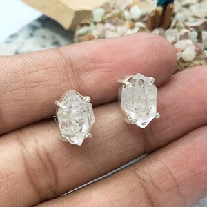 Peut inclure: Une paire de boucles d'oreilles en argent avec des pierres de quartz géométriques claires et facettées.