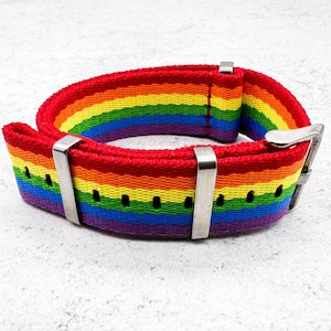 May include: A rainbow striped watch strap with a silver buckle.