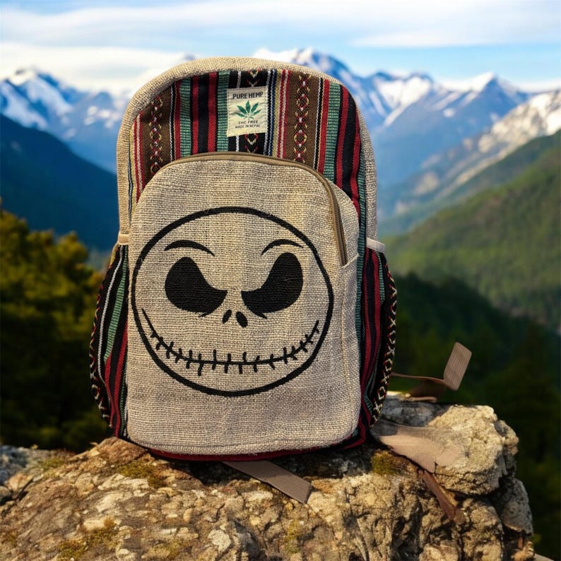 Puede incluir: Mochila de c&aacute;&ntilde;amo con la cara de Jack Skellington en el bolsillo delantero. La parte superior de la mochila tiene un dise&ntilde;o estampado con rayas rojas, verdes y marrones. Monta&ntilde;as en el fondo.