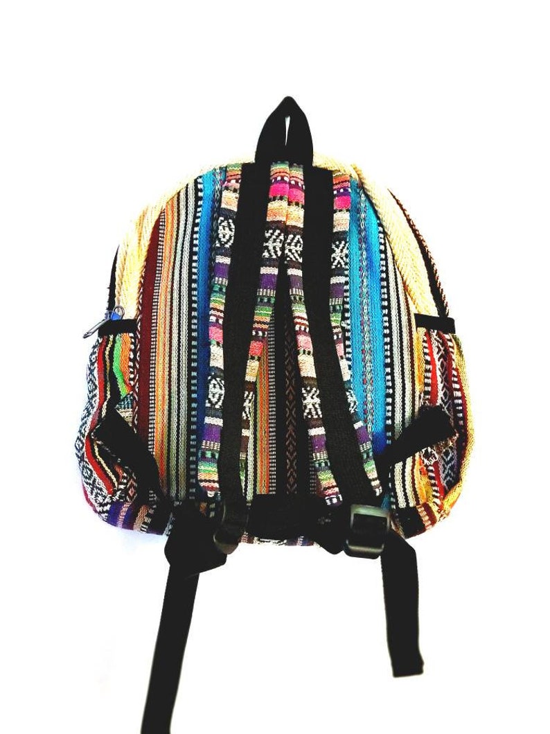 Puede incluir: Una colorida mochila con un dise&ntilde;o de tela tejida. La mochila presenta rayas verticales en tonos de rojo, naranja, amarillo, azul y morado. Tiene correas negras y un asa superior, con un bolsillo con cremallera en el lateral.