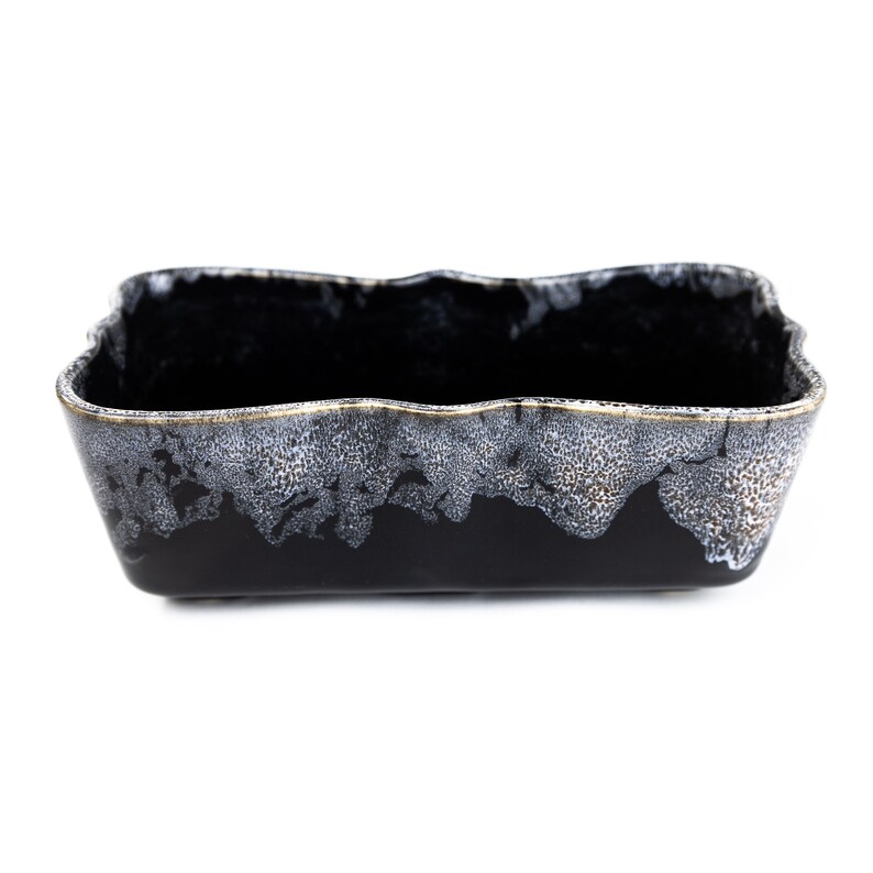 May include: A black ceramic planter with a wavy rim and a white and gold speckled glaze.