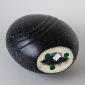 May include: Black ceramic vase with a speckled finish and a rounded shape. The bottom of the vase has a white sticker with the text "Kaga-ware" and the number "4341".