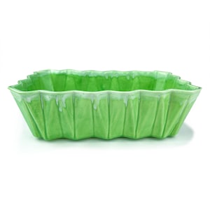 May include: A green ceramic planter with a unique, wavy, leaf-like design. The planter is made of glazed ceramic and has a smooth, glossy finish.