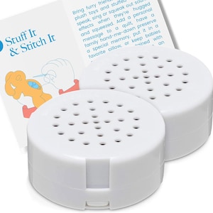 May include: Two round white plastic sound recording devices with perforated speaker grilles on top. Behind the devices is a white instructional card with the blue text Stuff It & Stitch It, featuring an illustration of a person sewing a plush toy.