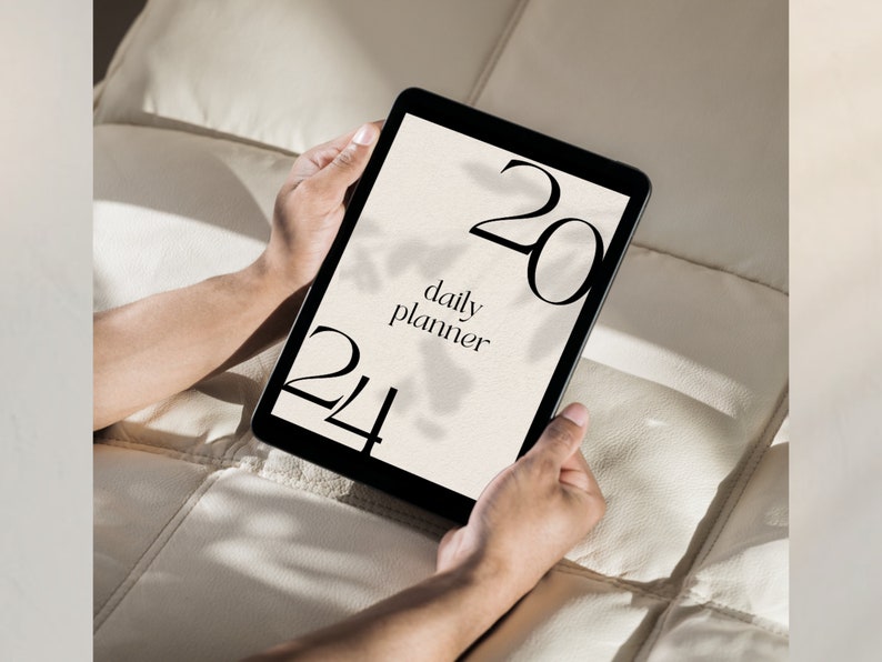 May include: A black tablet with a white screen displaying a daily planner with the text "daily planner" and the numbers "20" and "24" on the screen.