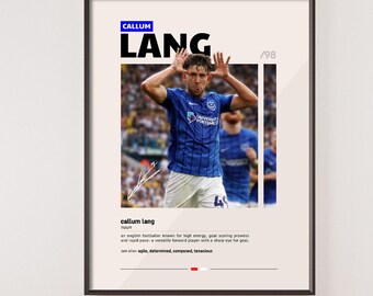 May include: A framed poster featuring a photograph of a soccer player in a blue jersey. The poster includes the name "Callum Lang" in large black letters, with additional text describing the player's attributes. The background is a light beige color.