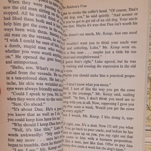 May include: A close-up of an open book with text about a man named Dan and his dog. The text reads, "Of course, Dan's an old dog, son," and "You've got to get rid of an old dog. Your uncle doesn't eat much, Mr. Kemp. Just one meal helps him get the cows in the evenings."