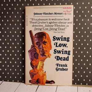 May include: A vintage paperback book cover with a yellow background and a black and white illustration of a man holding a gun. The title of the book is "Swing Low, Swing Dead" and the author is Frank Gruber. The book is a Johnny Fletcher Mystery.