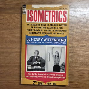 May include: A vintage paperback book titled ISOMETRICS by Henry Wittenberg, featuring a yellow cover with red and black text. The cover includes two black and white photographs of individuals performing exercises and states it is the 2nd giant printing.