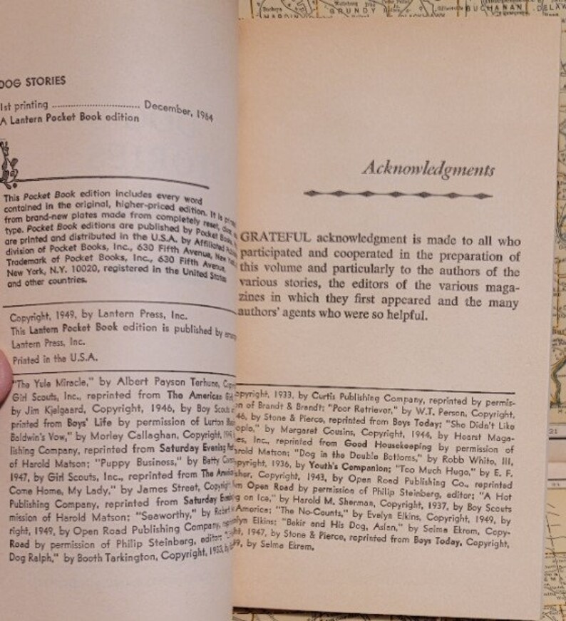 May include: A book titled "Dog Stories" with a copyright date of December 1964. The book cover features a black and white illustration of a dog with a red collar. The book includes a list of stories and their authors, including "The Yule Miracle" by Albert Payson Terhune, "Baldwin's Vow" by Morley Callaghan, and "Puppy Business" by Batty Archer.