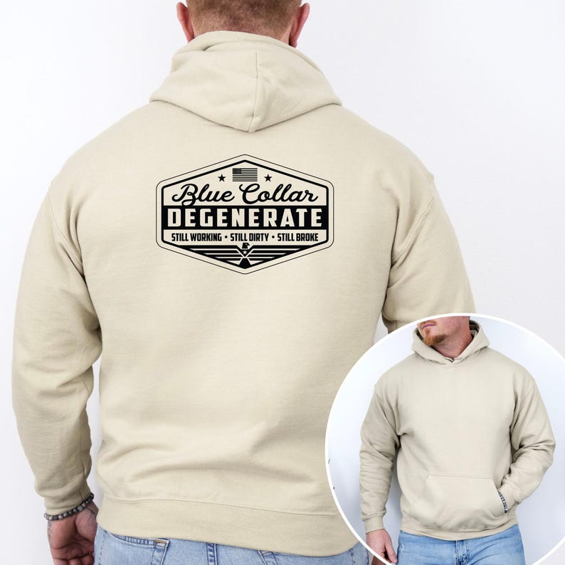 May include: A beige hoodie with a front pocket and a drawstring hood. The back of the hoodie features a black and white graphic with the text "Blue Collar Degenerate" and the phrases "Still Working, Still Dirty, Still Broke."