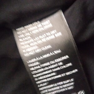 May include: Black care label with white text detailing washing instructions. Hand wash cold, do not wring or twist, use only non-chlorine bleach, reshape lay flat to dry, cool iron on reverse side if needed, do not dry clean, laver a la main a l'eau froide, ne pas tordre ou essorer, utiliser un agent de blanchiment sans chlore si necessaire, mettre en forme et secher a plat, refroidir le fer sur le cote inverse si besoin, nettoyer a sec.