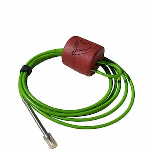 May include: A bright green cord coiled into a circle, featuring a cylindrical red weight with a small etched graphic of a bird. The cord includes a black fastener and a metallic silver tip at one end, providing a functional and distinct appearance.