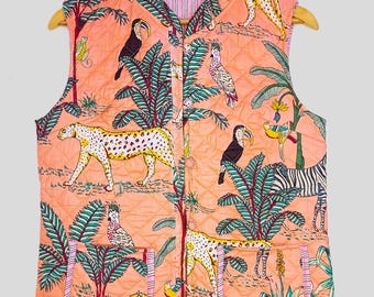 May include: A coral-coloured quilted vest with a jungle-themed print. The sleeveless vest features a repeating pattern of leopards, toucans, zebras, and foliage. It has two pockets and a pink striped lining. The vest is displayed on a wooden hanger.