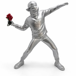 Puede incluir: Escultura plateada de una figura con gorra y cubrebocas, sosteniendo un ramo de rosas rojas y extendiendo el otro brazo. La figura viste camisa de manga larga, pantalones y botas.