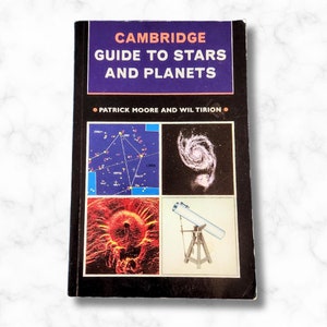 May include: A vintage paperback book titled "Cambridge Guide to Stars and Planets" by Patrick Moore and Wil Tirion. The cover features four images: a star chart, a spiral galaxy, a close-up of the sun, and a telescope.