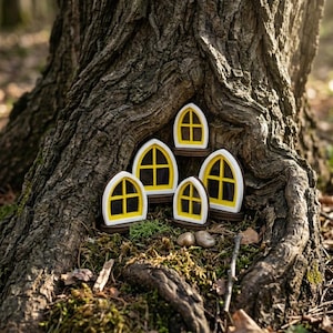 May include: A set of four miniature arched windows with bright yellow frames and white trim, arranged in a cluster. Each window features a central cross-mullion design, creating a small decorative display against the textured bark of a tree.
