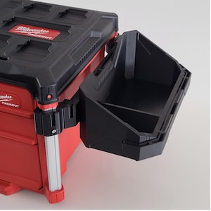 May include: A red and black Milwaukee Packout tool box with an attached black storage bin. The tool box has the Milwaukee Packout logo on the top and side. The storage bin is open and has two compartments.