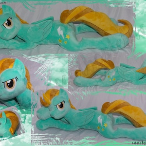 Op de afbeelding: Een turquoise blauwe pluche pony met een gele manen en staart. De pony heeft een bliksem en sterren op zijn flank. De pony ligt op zijn zij met zijn hoofd rustend op zijn voorpoot.