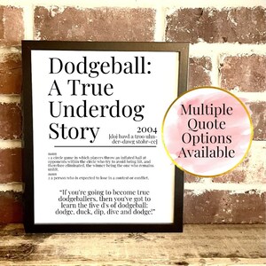 May include: A framed print with the text "Dodgeball: A True Underdog Story" and a definition. A pink circle with gold trim reads "Multiple Quote Options Available". The print is on a wooden surface against a brick wall.