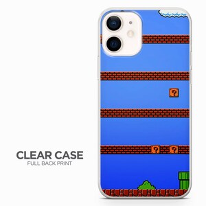 May include: A clear phone case with a full back print of a retro video game level. The level features a blue background with red brick blocks, question mark blocks, and a green pipe.